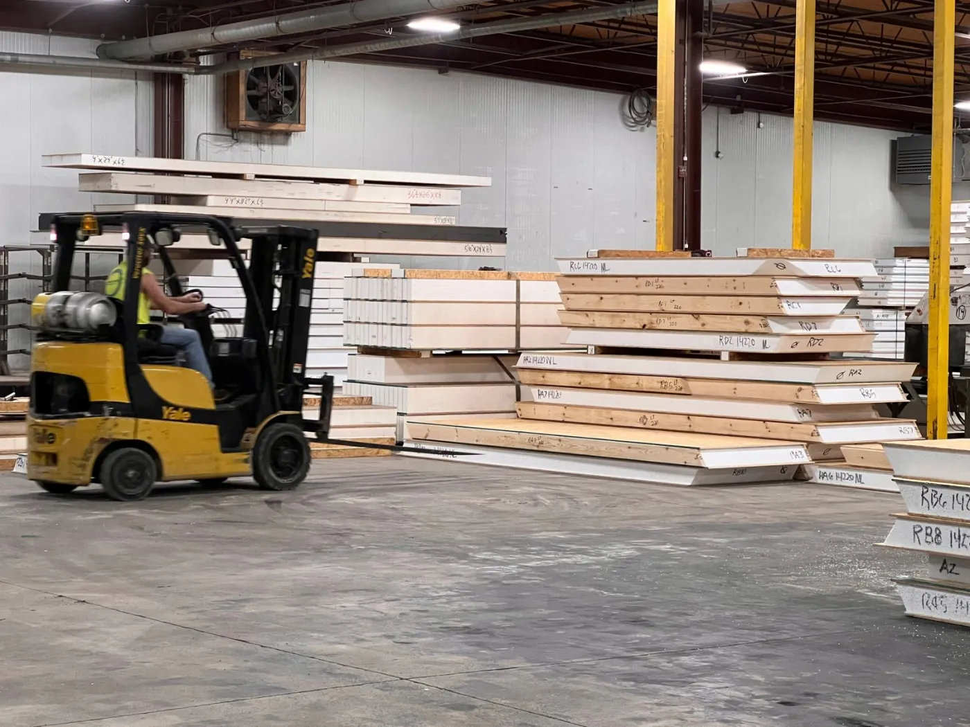 A forklift moving stacks of finished wall panels