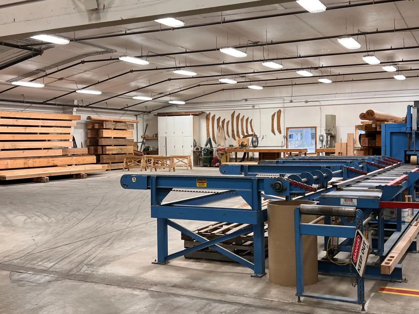 Panel cutting line with a long conveyor table and lumber stacked behind