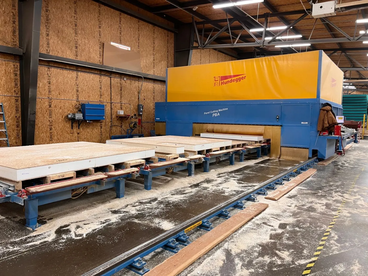 An automated cutting machine processing a panel on the line