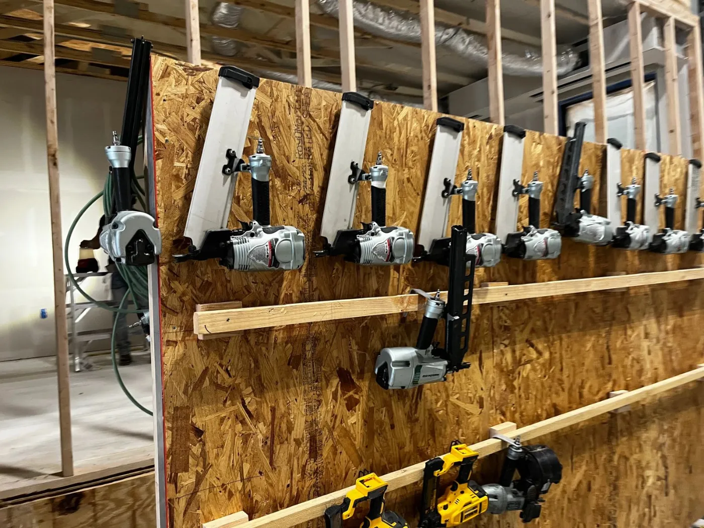 A framed wall on the line, with power tools hanging ready