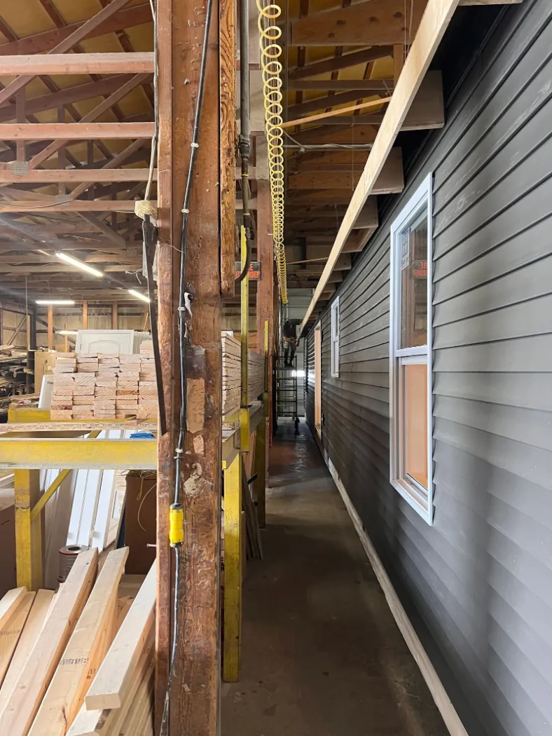 A narrow aisle between finished module walls with siding