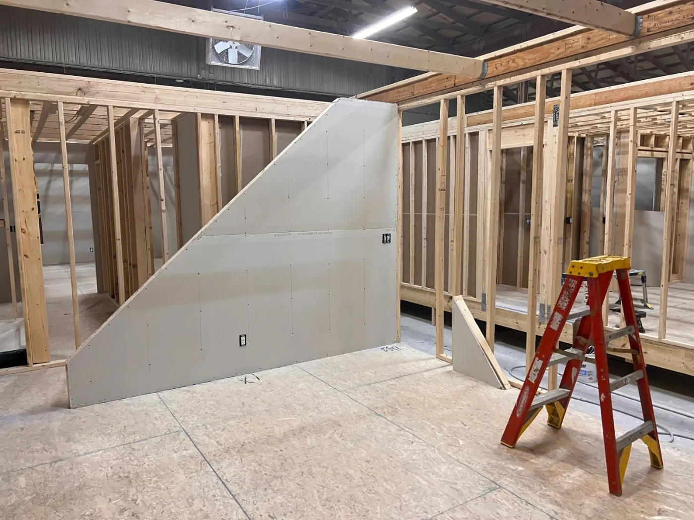 The interior of a module with drywall and a stepladder