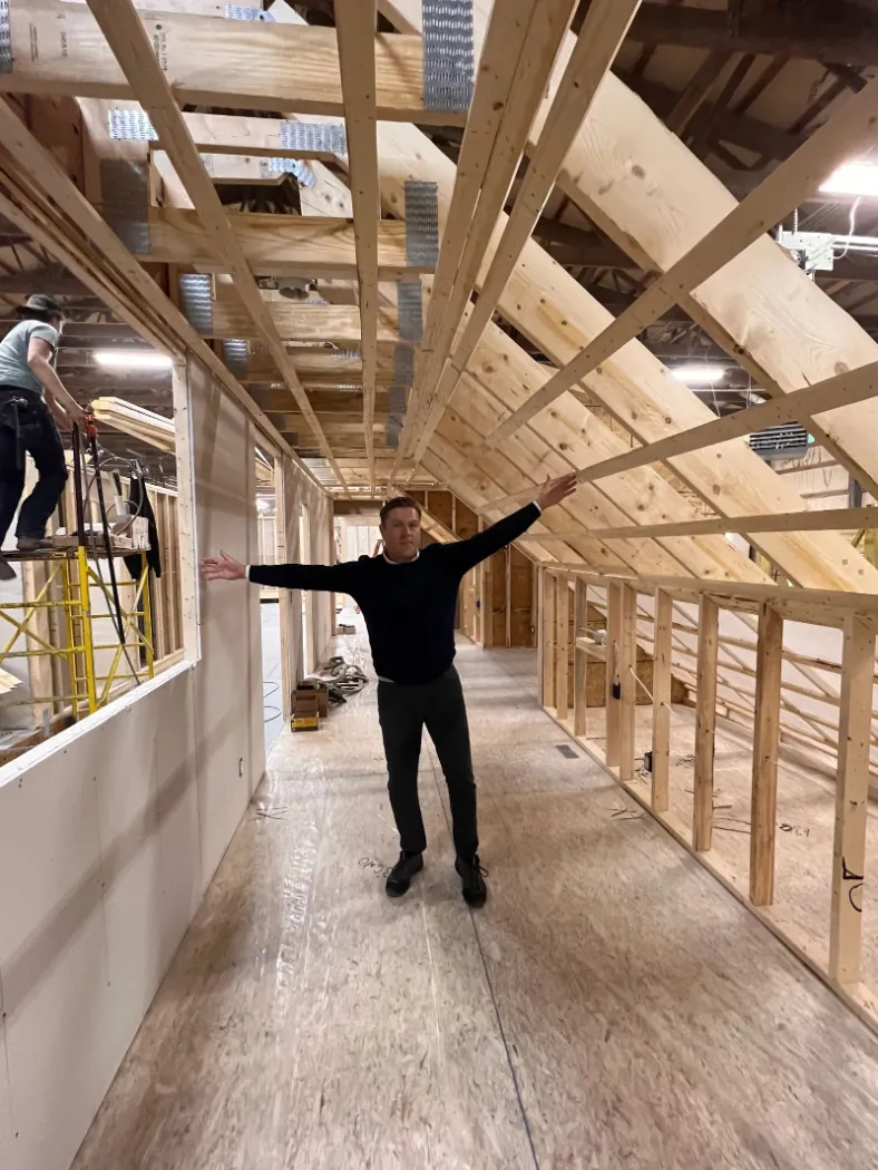 A team member standing inside a framed module
