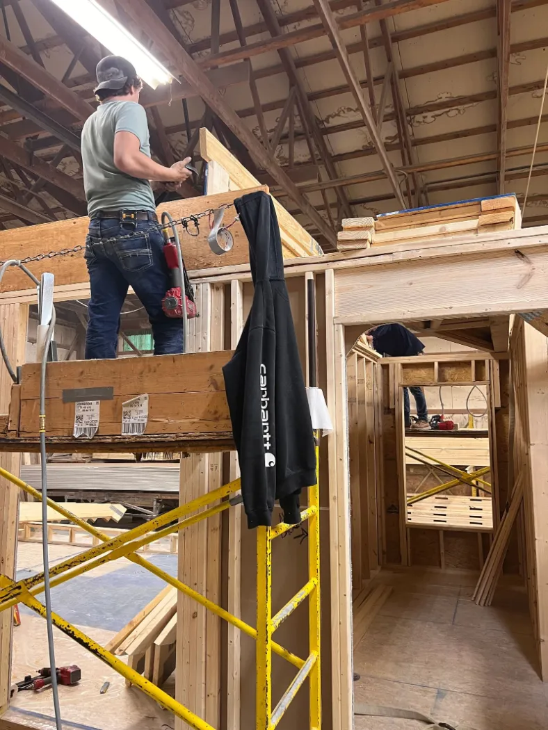 Workers on scaffolding framing a module