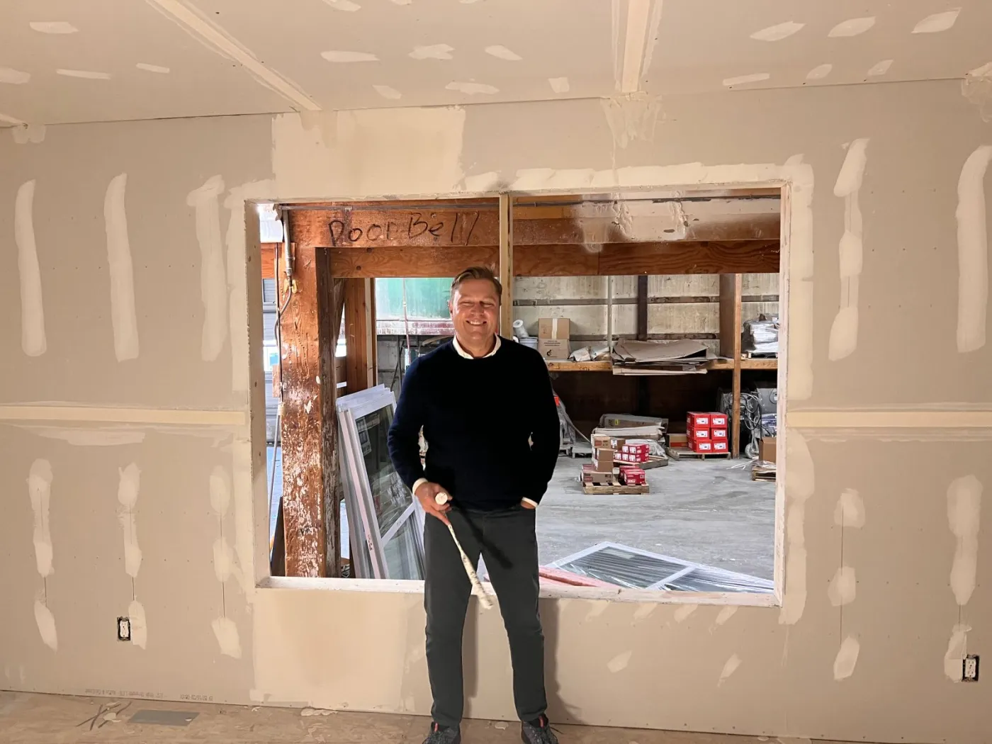 A team member standing in a window opening of a module under construction