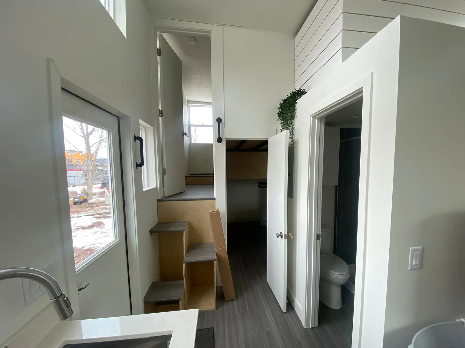 Entry hall with storage stairs up to a loft, a closet, and the bathroom door