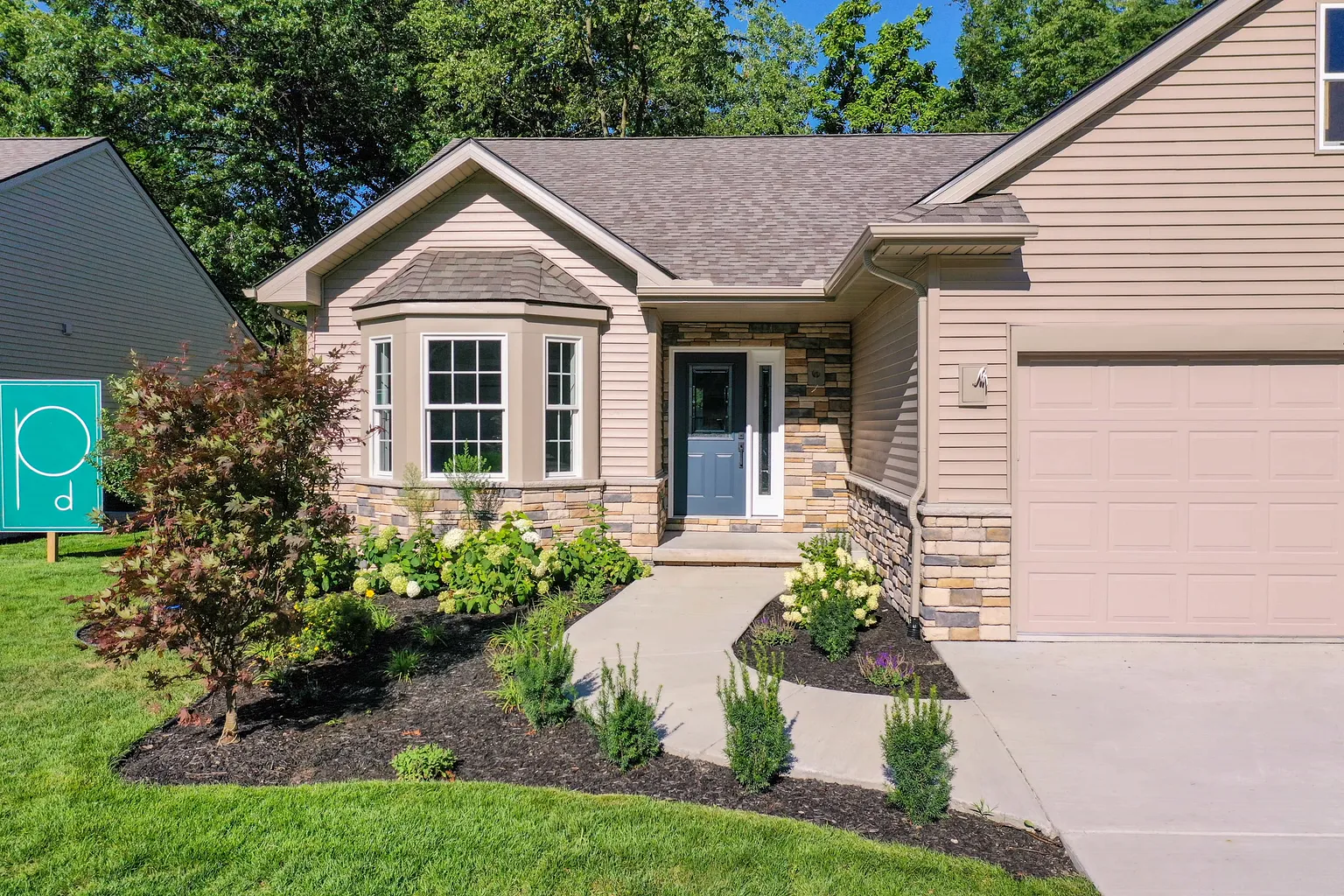 Front entry with a blue door, stone surround, bay window, and new plantings