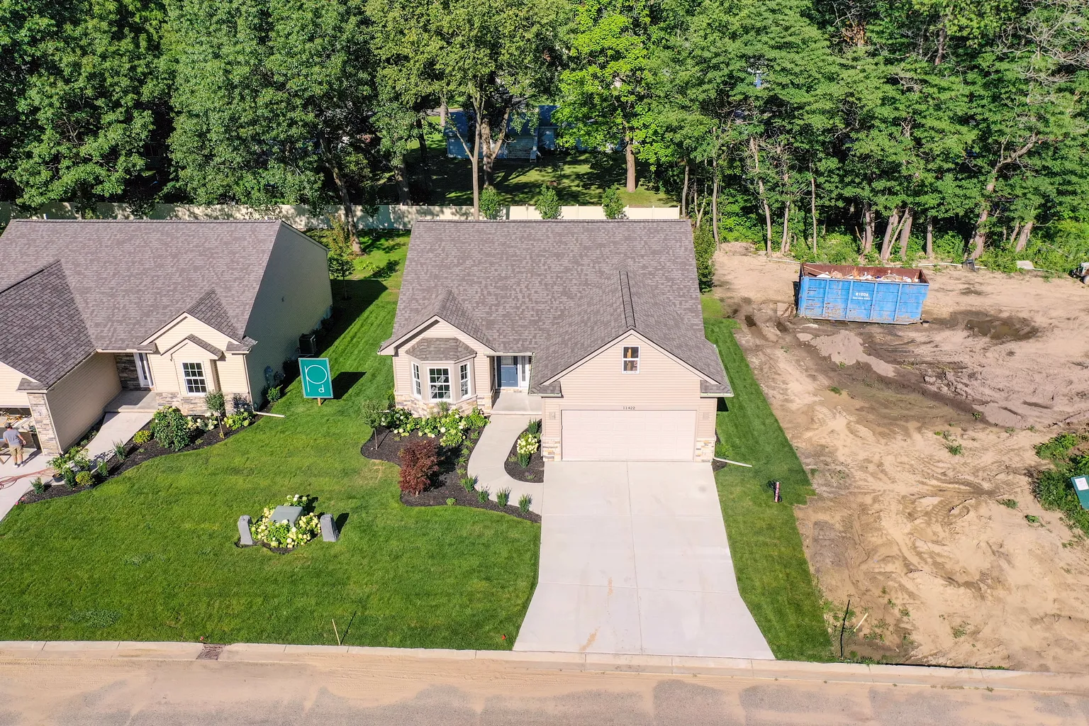 Aerial view of the home and its neighbors along a new street, with lots still under construction