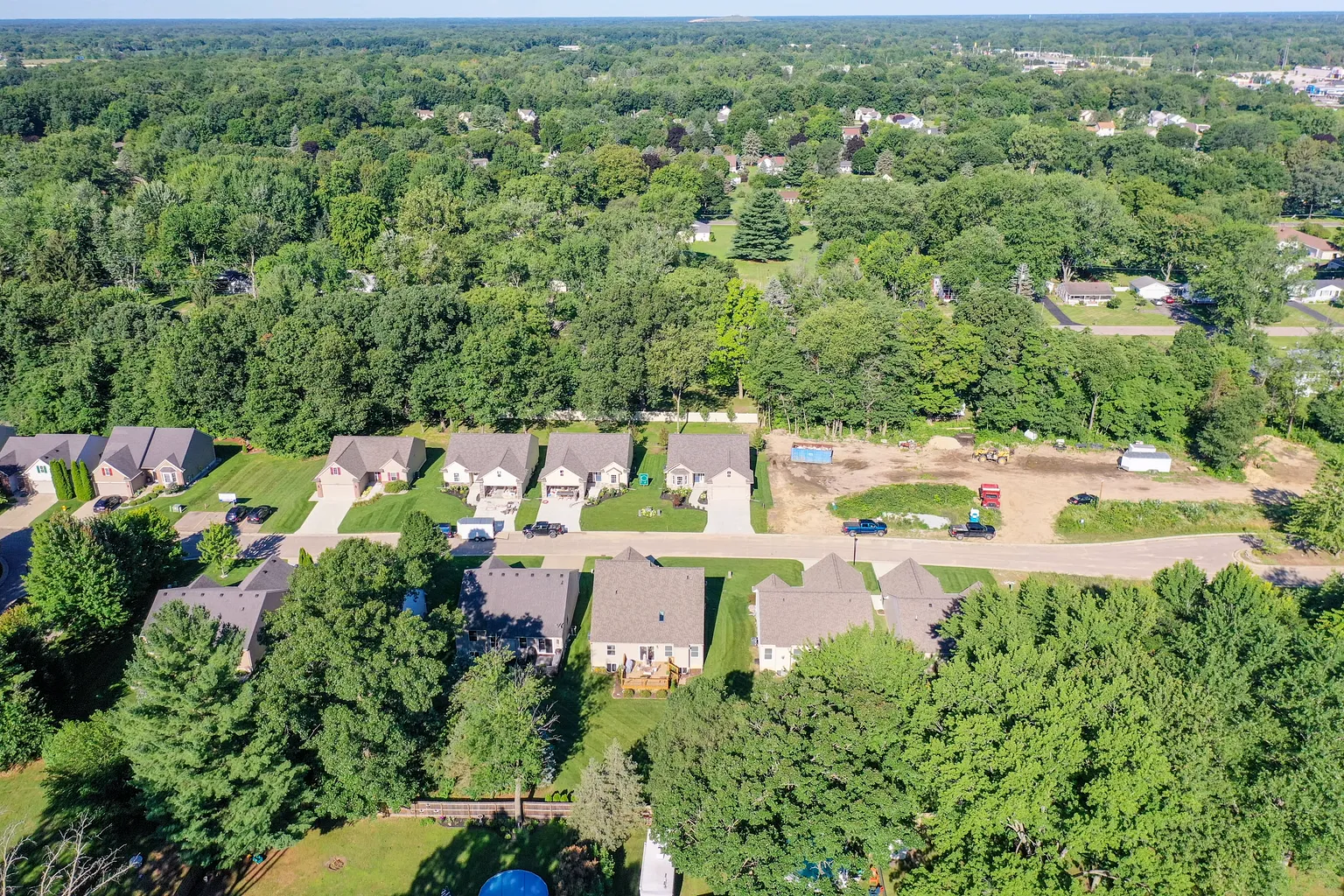 Overhead view of three new homes in a row beside an open lot