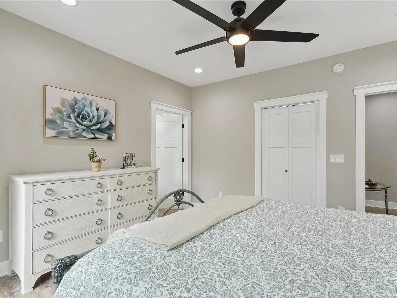 Primary bedroom with ceiling fan and natural light