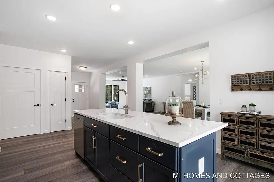 Navy kitchen island with a quartz top, looking through to the living and dining rooms