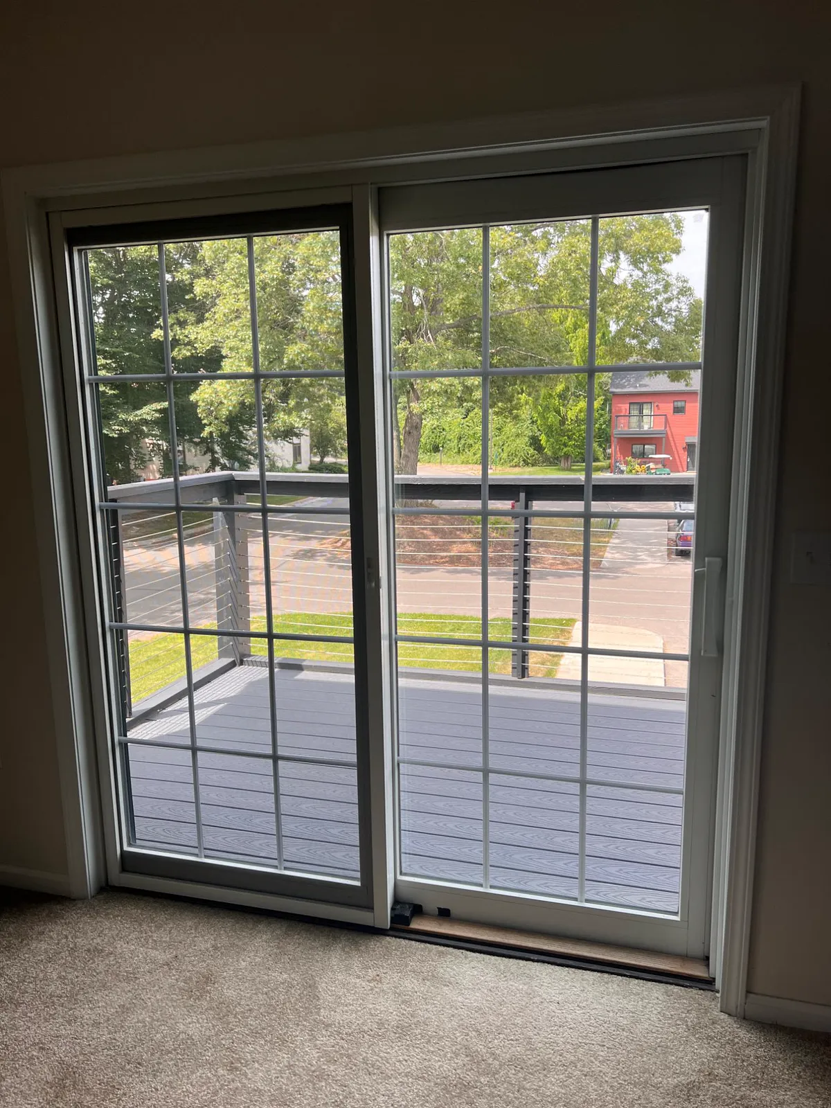 Sliding patio door opening onto a balcony with cable railing