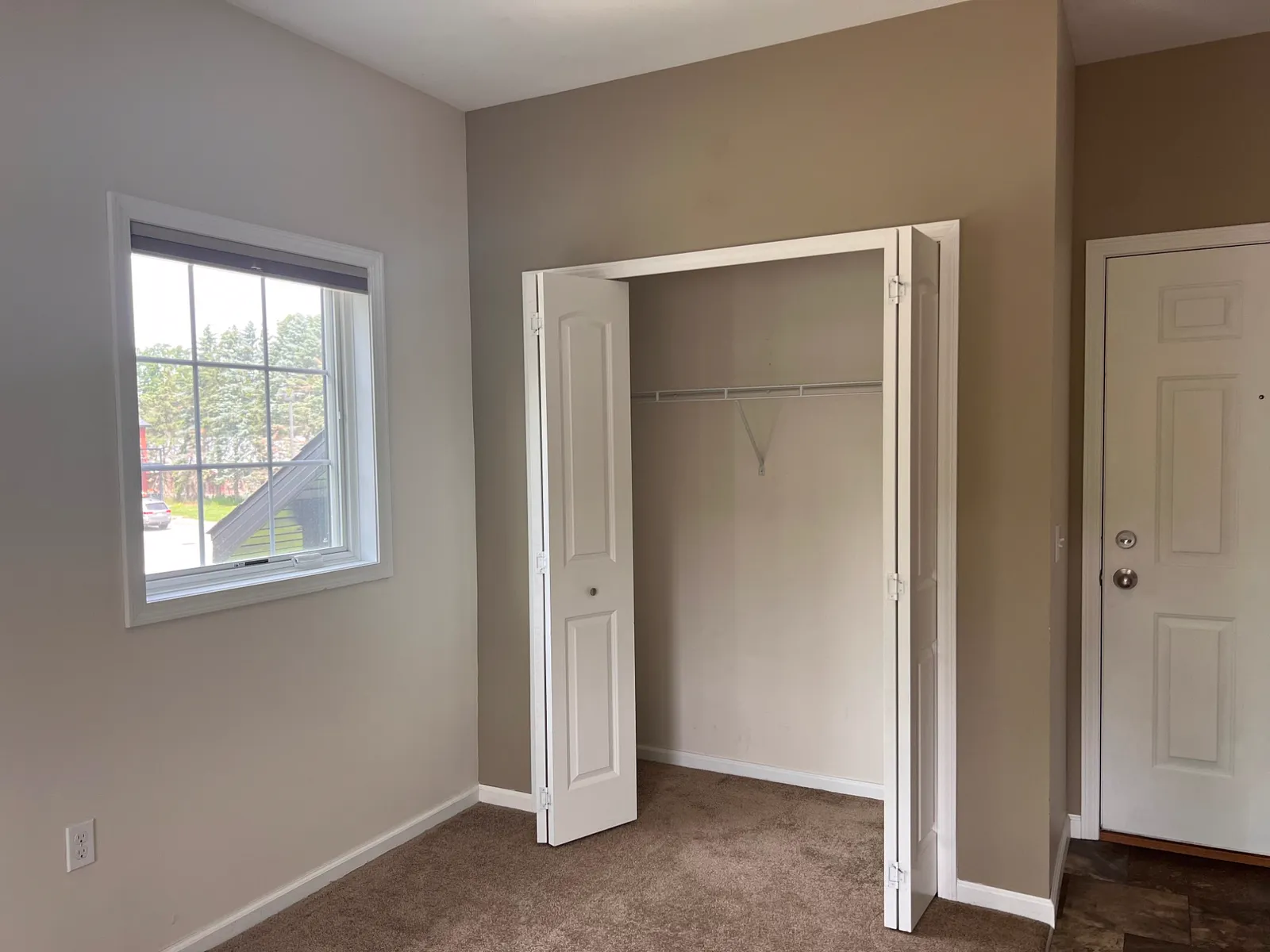 Bedroom with a window and a double closet with bifold doors